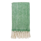 Groene plaid van wolmix op bank in woonkamer