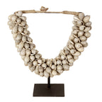 Handgemaakte schelpenketting op metalen standaard als woondecoratie