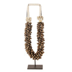 Handgemaakte schelpenketting op metalen standaard als woondecoratie